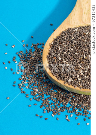 Healthy breakfast, Chia seeds or superfood in wooden spoon and falling on light blue background 97315432