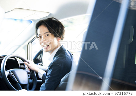 man in the driver's seat of a car 97316772