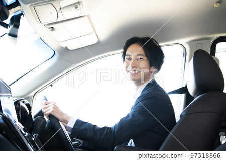 A man driving a car looking at the camera A man driving a car looking at the camera 97318866