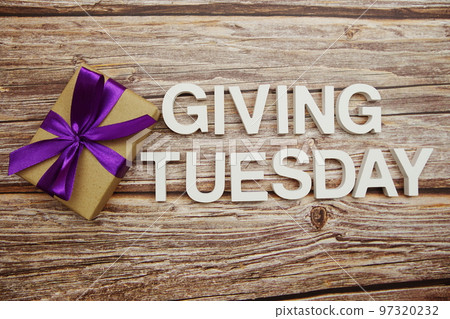 Giving Tuesday alphabet letters and gift box on wooden background Giving Tuesday alphabet letters and gift box on wooden background 97320232