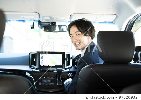 man in the driver's seat of a car 97320932