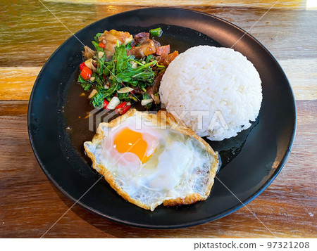 Rice topped with crispy pork belly with Thai basil and fried egg Rice topped with crispy pork belly with Thai basil and fried egg 97321208