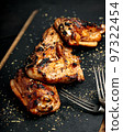 BBQ chicken thighs on a black cutting board. Soft focus. Vertical shot 97322454