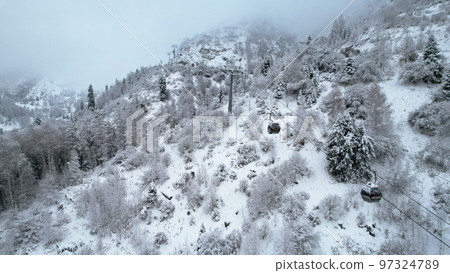 Cable car in the mountains in the winter forest 97324789