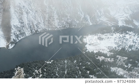 Flying in the clouds over the Kolsai mountain lake Flying in the clouds over the Kolsai mountain lake 97324886