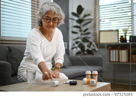 Shot of diabetic senior woman taking daily medicine. Elderly healthcare, pharmaceutical concept 97325065