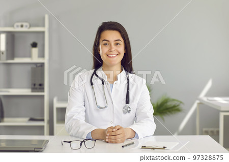 Friendly young female doctor providing online consultation to her patients via video link. 97328875