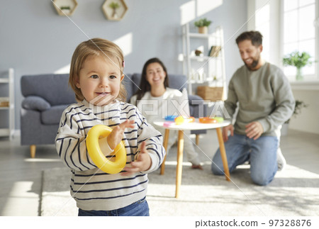 Portrait of cute little child girl playing with colorful rainbow toy pyramid details. Portrait of cute little child girl playing with colorful rainbow toy pyramid details. 97328876