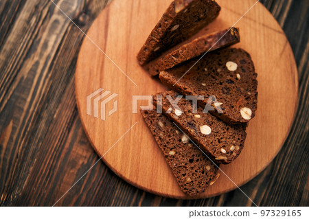 sliced whole-grain bread on a wooden board. sliced whole-grain bread on a wooden board. 97329165