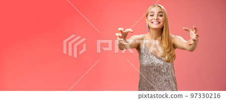Excited obsessed attractive crazy blond woman in glamour silver dress smiling weird thrilled stretch hands like claws wanna embrace hug ex-boyfriend being clingy, standing red background 97330216