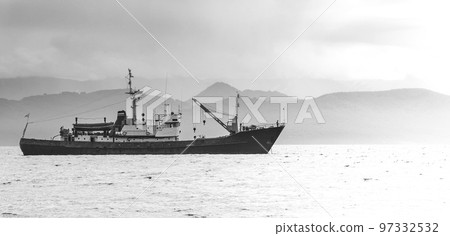 large fishing vessel on the background of hills and volcanoes 97332532