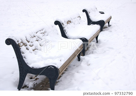 Wooden bench under the snow in the park Wooden bench under the snow in the park 97332790