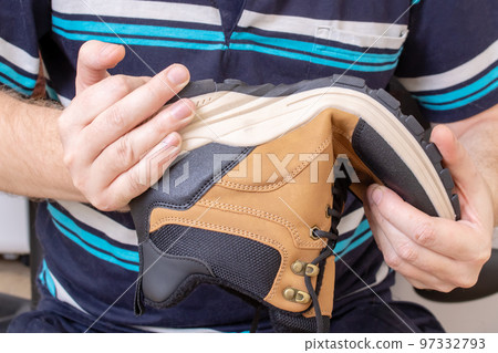 Brown shoe in the hands of a man Brown shoe in the hands of a man 97332793