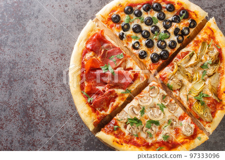 Delicious crispy Italian pizza four seasons with mushrooms, artichokes, prosciutto ham and olives close-up on the table. Horizontal top view 97333096