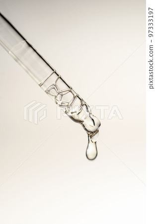 A drop of cosmetic oil falls from the pipette 97333197