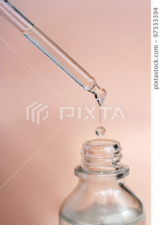 A drop of cosmetic oil falls from the pipette 97333394