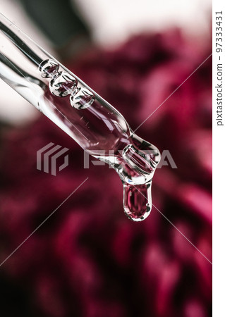 A drop of cosmetic oil falls from the pipette A drop of cosmetic oil falls from the pipette 97333431