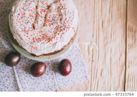 Easter table with traditional Easter cakes and Easter eggs with blossoming tree branch Easter table with traditional Easter cakes and Easter eggs with blossoming tree branch 97333764