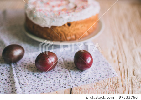 Easter table with traditional Easter cakes and Easter eggs with blossoming tree branch Easter table with traditional Easter cakes and Easter eggs with blossoming tree branch 97333766