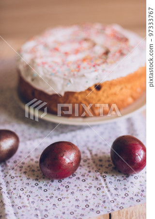 Easter table with traditional Easter cakes and Easter eggs with blossoming tree branch Easter table with traditional Easter cakes and Easter eggs with blossoming tree branch 97333767