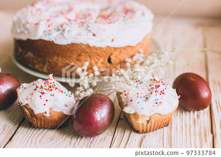 Easter table with traditional Easter cakes and Easter eggs with blossoming tree branch Easter table with traditional Easter cakes and Easter eggs with blossoming tree branch 97333784