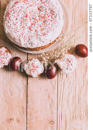 Easter table with traditional Easter cakes and Easter eggs with blossoming tree branch Easter table with traditional Easter cakes and Easter eggs with blossoming tree branch 97333797