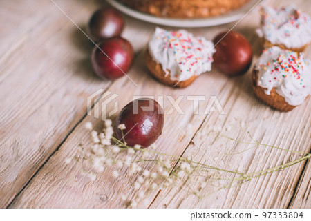 Easter table with traditional Easter cakes and Easter eggs with blossoming tree branch Easter table with traditional Easter cakes and Easter eggs with blossoming tree branch 97333804