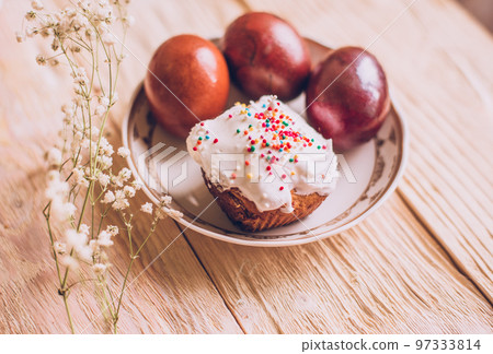Easter table with traditional Easter cakes and Easter eggs with blossoming tree branch Easter table with traditional Easter cakes and Easter eggs with blossoming tree branch 97333814