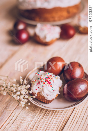 Easter table with traditional Easter cakes and Easter eggs with blossoming tree branch Easter table with traditional Easter cakes and Easter eggs with blossoming tree branch 97333824