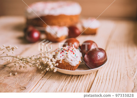 Easter table with traditional Easter cakes and Easter eggs with blossoming tree branch Easter table with traditional Easter cakes and Easter eggs with blossoming tree branch 97333828