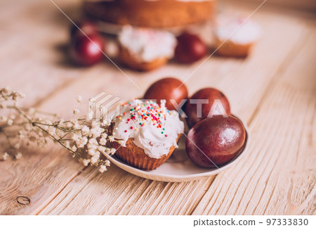 Easter table with traditional Easter cakes and Easter eggs with blossoming tree branch Easter table with traditional Easter cakes and Easter eggs with blossoming tree branch 97333830