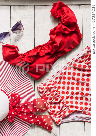 Feminine red retro swimsuit, hat and beach accessories on white wooden background. Flat lay, top view,summer and travel concept 97334233