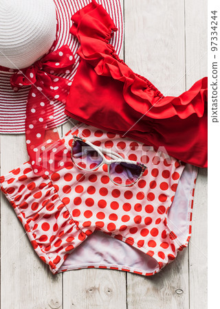 Feminine red retro swimsuit, hat and beach accessories on white wooden background. Flat lay, top view,summer and travel concept 97334244