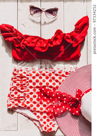 Feminine red retro swimsuit, hat and beach accessories on white wooden background. Flat lay, top view,summer and travel concept 97334252