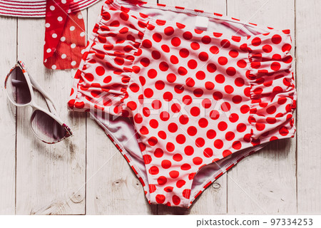 Feminine red retro swimsuit, hat and beach accessories on white wooden background. Flat lay, top view,summer and travel concept 97334253