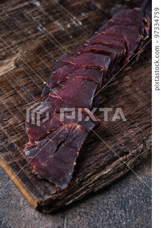 homemade jerky meat, basturma on a kitchen cutting board homemade jerky meat, basturma on a kitchen cutting board 97334759