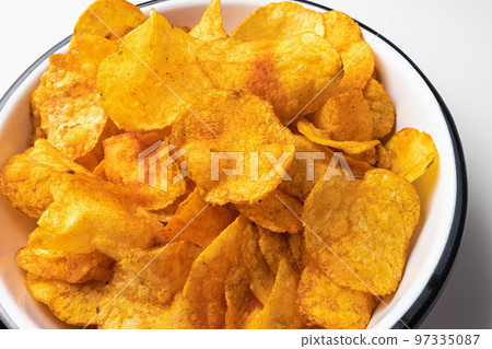 Smoked paprika potato chips in bowl on white background. Fast food, junk food and unhealthy snacks concept, closeup 97335087