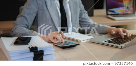 Business women are calculating income-expenditure and analyzing real estate investment data at office, Accounting Financial and tax systems concept. 97337140
