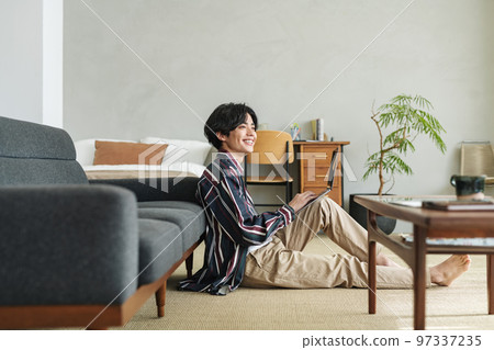 A young man using a computer in a stylish room 97337235