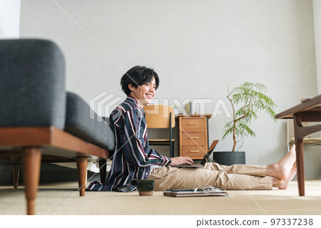 一個年輕人在時尚的房間裡使用電腦 97337238