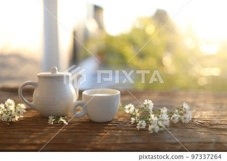 Tea cup and tea pot and aster flowers in on wooden table  97337264