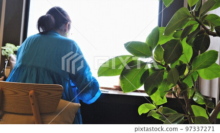 Woman sitting by window at tea break 97337271