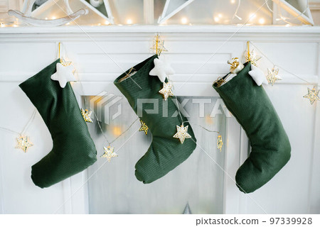 Christmas socks for Santa Claus gifts hang over the fireplace in the house 97339928