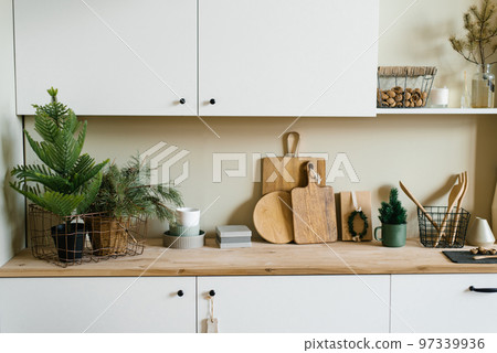 Scandinavian style kitchen utensils. Wooden cutting boards, wooden spoons and shovels. tree in a pot. Christmas decor 97339936