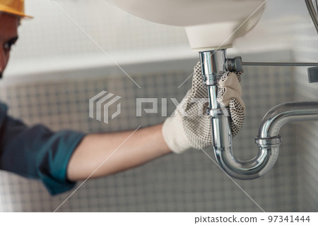 Close up of plumber is repairing faucet at bathroom. Good quality plumbing company service 97341444