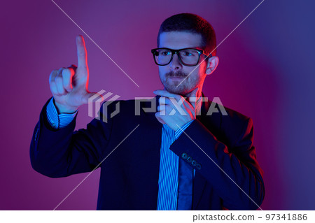 Serious young caucasian businessman in business suit and eyewear looking with thoughtful facial expression over purple background. 97341886