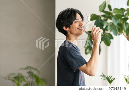 young man drinking green juice 97342149