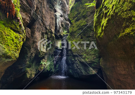 View of the small flow of water between the rocks. Waterfall in the mountains. View of the small flow of water between the rocks. Waterfall in the mountains. 97343179