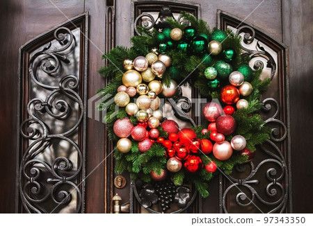 Holiday christmas wreath with balls on front door Holiday christmas wreath with balls on front door 97343350