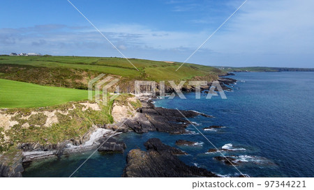 Green hills on the Atlantic Ocean on a sunny spring day. Blue sky over the sea coast. The coastline of Ireland, West Cork. View from above. 97344221